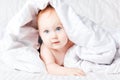 Cute and funny little baby smiling under white blanket. Copy spa Royalty Free Stock Photo