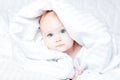 Cute and funny little baby smiling under white blanket. Copy spa Royalty Free Stock Photo