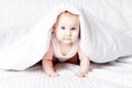 Cute and funny little baby smiling under white blanket. Copy spa Royalty Free Stock Photo