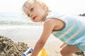 Cute funny little boy playing with sand at sea shore. Summer beach vacation, holiday travel, beach scene concept. Royalty Free Stock Photo