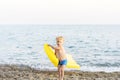 Cute funny little boy playing with yellow swimming mattress at sea shore. Summer beach vacation, childhood lifestyle Royalty Free Stock Photo