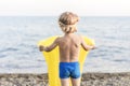 Cute funny little boy playing with yellow swimming mattress at sea shore. Summer beach vacation, childhood lifestyle Royalty Free Stock Photo