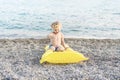 Cute funny little boy playing with yellow swimming mattress at sea shore. Summer beach vacation, childhood lifestyle Royalty Free Stock Photo