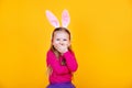 Cute funny little child girl is wearing bunny ears on blue background. Happy easter Royalty Free Stock Photo