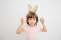 Cute funny little girl with bunny ears and Easter eggs on white  background. Happy Easter and Spring concept Royalty Free Stock Photo