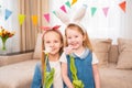 little girls with a red headband and rabbit ears hold pink tulip flower in hands