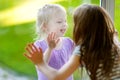 Cute funny little sisters playnig by a window Royalty Free Stock Photo