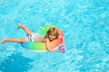 Cute funny little toddler boy in a colorful swimming suit and sunglasses relaxing with toy ring floating in a pool Royalty Free Stock Photo