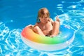 Cute funny little toddler child boy with thumb up in a colorful swimming suit and sunglasses relaxing. Kid with toy ring Royalty Free Stock Photo