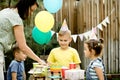 Cute funny nine year old boy celebrating his birthday with family or friends and eating homemade baked cake in a backyard.