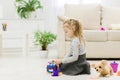 Cute funny preschooler little girl playing with construction toy blocks building a tower in a sunny room. Royalty Free Stock Photo