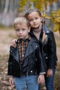 Cute funny smiling little girl and boy are hugging in autumn park. Happy cheerful kids Royalty Free Stock Photo