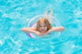 Cute funny teen girl in a swimsuit with an inflatable lifebuoy swims in the pool Royalty Free Stock Photo