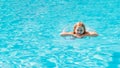 Cute funny teen girl in a swimsuit with an inflatable lifebuoy swims in the pool Royalty Free Stock Photo