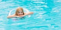 Cute funny teen girl in a swimsuit with an inflatable lifebuoy swims in the pool Royalty Free Stock Photo