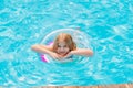 Cute funny teen girl in a swimsuit with an inflatable lifebuoy swims in the pool Royalty Free Stock Photo