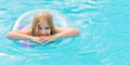 Cute funny teen girl in a swimsuit with an inflatable lifebuoy swims in the pool Royalty Free Stock Photo