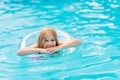 Cute funny teen girl in a swimsuit with an inflatable lifebuoy swims in the pool Royalty Free Stock Photo