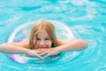 Cute funny teen girl in a swimsuit with an inflatable lifebuoy swims in the pool Royalty Free Stock Photo