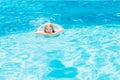 Cute funny teen girl in a swimsuit with an inflatable lifebuoy swims in the pool Royalty Free Stock Photo