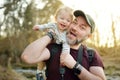 Cute funny toddler boy and his father hiking in the woods. Dad and son having fun on a walking trail on sunny spring day