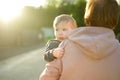 Cute funny toddler boy in his mothers arms. Mom and son having fun on sunny summer day in a park. Adorable son being held by mommy Royalty Free Stock Photo