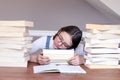 Cute funny tween girl in glasses tired of reading and studying sleeping on books between stack of books Royalty Free Stock Photo