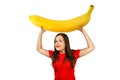 Cute funny young girl holds over herself huge banana, isolated on a white background Royalty Free Stock Photo