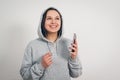 Cute funny young girl the woman in the grey hoodie listening to music from your smartphone through the headset