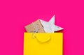 Cute gift and star shaped toy in beautiful yellow shopping bag o Royalty Free Stock Photo