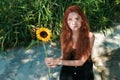 Cute ginger girl with sunflower in park Royalty Free Stock Photo