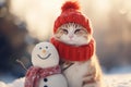 A cute ginger and white cat in a red knitted hat and scarf sits near snowman. Snowy warm cottagecore winter background. Concept of