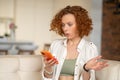 Cute ginger woman with a smartphone in hands