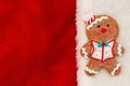 Cute gingerbread man on red plush material holiday background