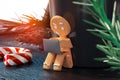 Cute gingerbread working on laptop and sitting near to mug. 3d rendering.