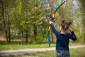 Cute girl archer with bow shooting in sunny summer day. little girl shoots bow in the park. Outdoors. Sport activities with Royalty Free Stock Photo