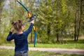 Cute girl archer with bow shooting in sunny summer day. little girl shoots bow in the park. Outdoors. Sport activities with Royalty Free Stock Photo