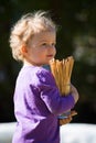 Cute girl baby with blond hairs holds glass