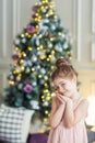 Cute girl on the background of the Christmas tree. portrait of a child in the new year interior