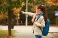 Cute girl with backpack pointing at something outdoors Royalty Free Stock Photo