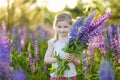 Cute girl in blooming lupine field