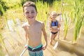 Cute girl and boy fishing with a net on a lake