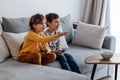Cute girl and boy laughing and choosing cartoons in tv Royalty Free Stock Photo
