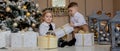 Cute Girl and boy opening Xmas presents. Children under Christmas tree with gift boxes. Decorated living room with traditional Royalty Free Stock Photo