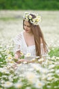 Cute girl in camomile meadow