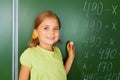 Cute girl with chalk in hand near blackboard Royalty Free Stock Photo