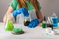 Cute girl in chemistry glasses impressed by green crystal growth. Science is fun concept with