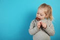 Cute girl child eating sweet chocolate candy on blue background. Happy childhood Royalty Free Stock Photo