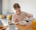 Cute girl child put cereal oat meal for breakfast Royalty Free Stock Photo