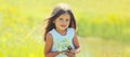 Cute girl child with wildflowers in sunny summer park Royalty Free Stock Photo